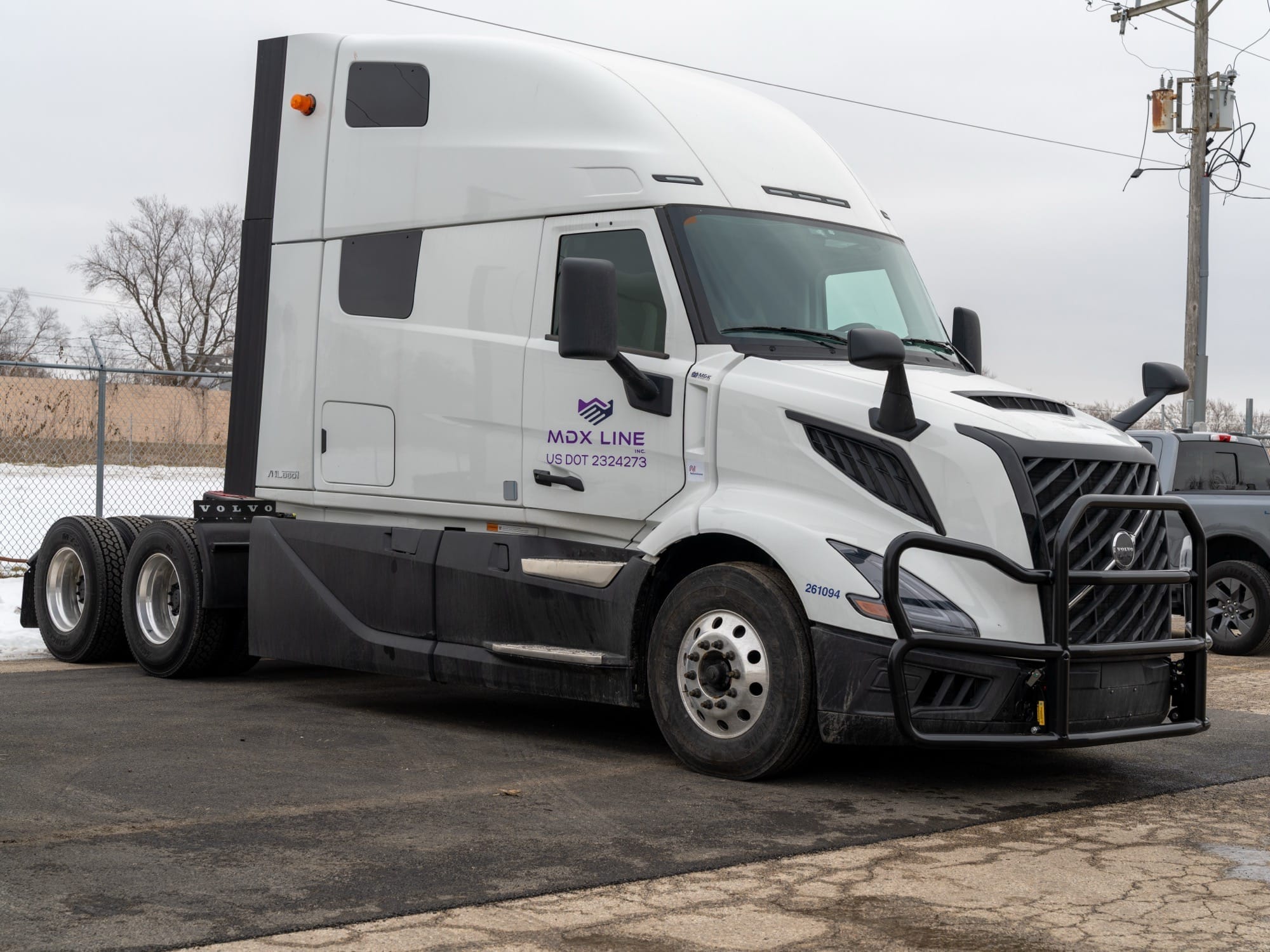 MDX Line Freightliner hauling a loaded flatbed trailer